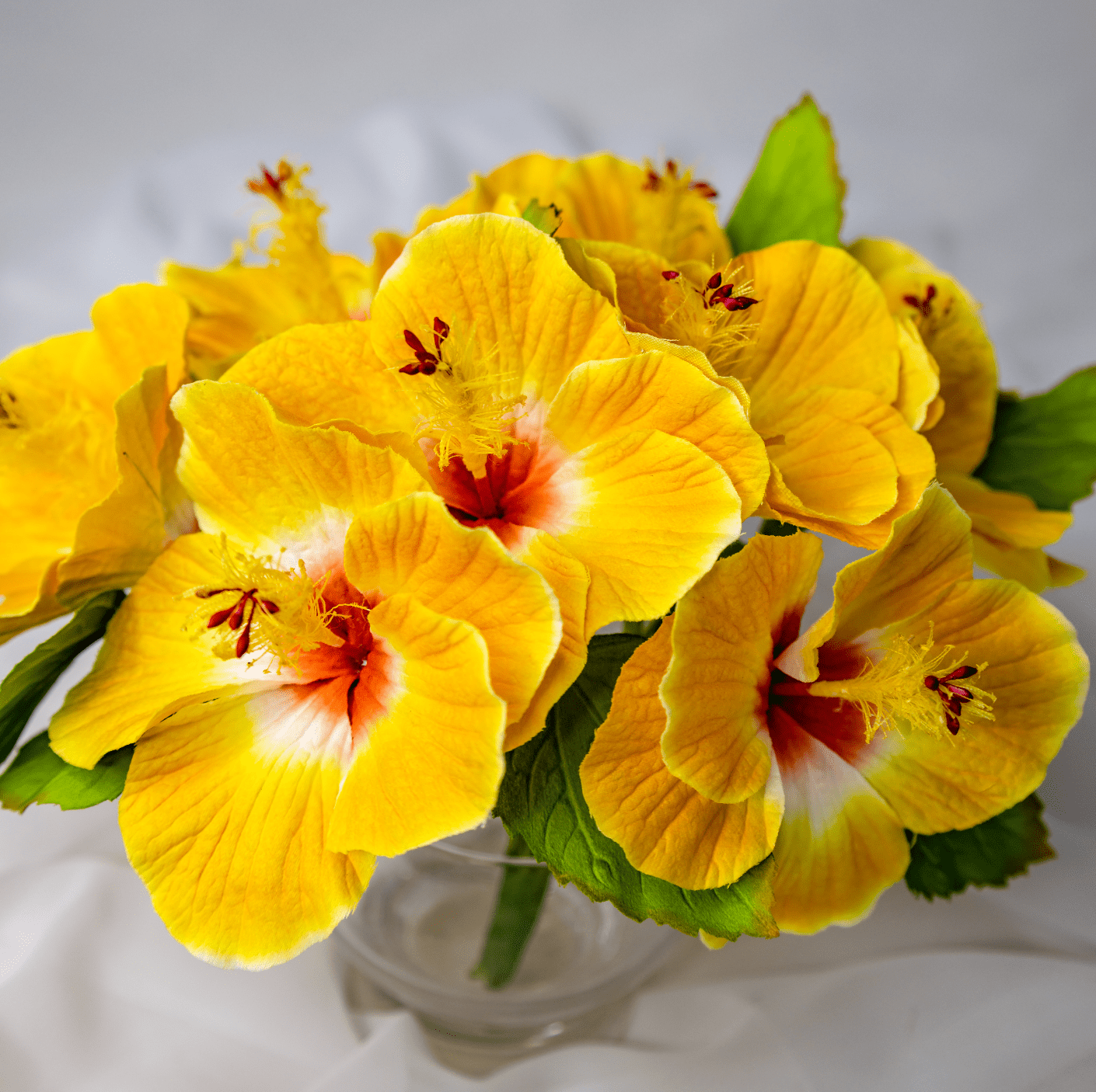 artificial Yellow Hibiscus Flowerhead in clear glass vase