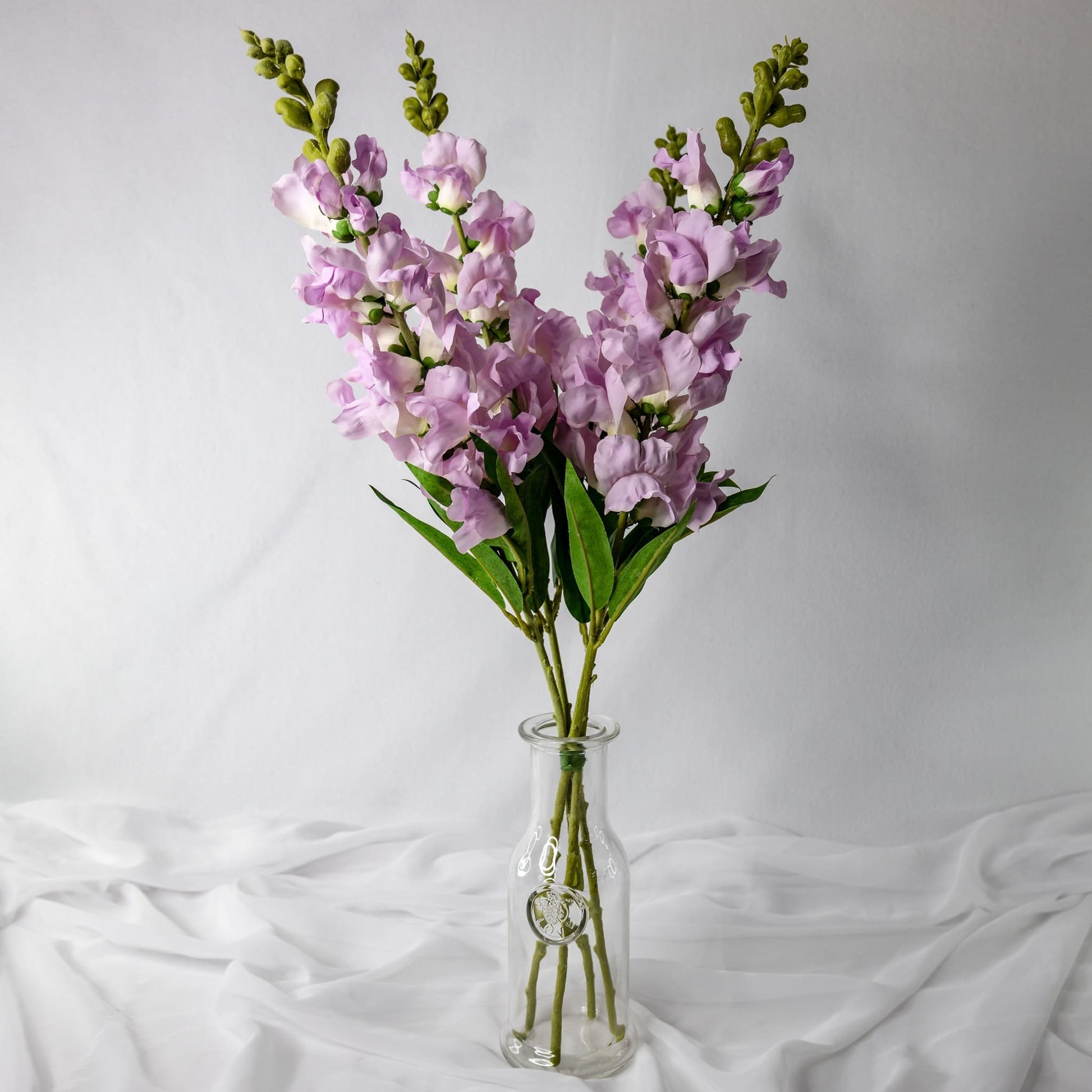 artificial Lavender Snap Dragons in clear transparent vase
