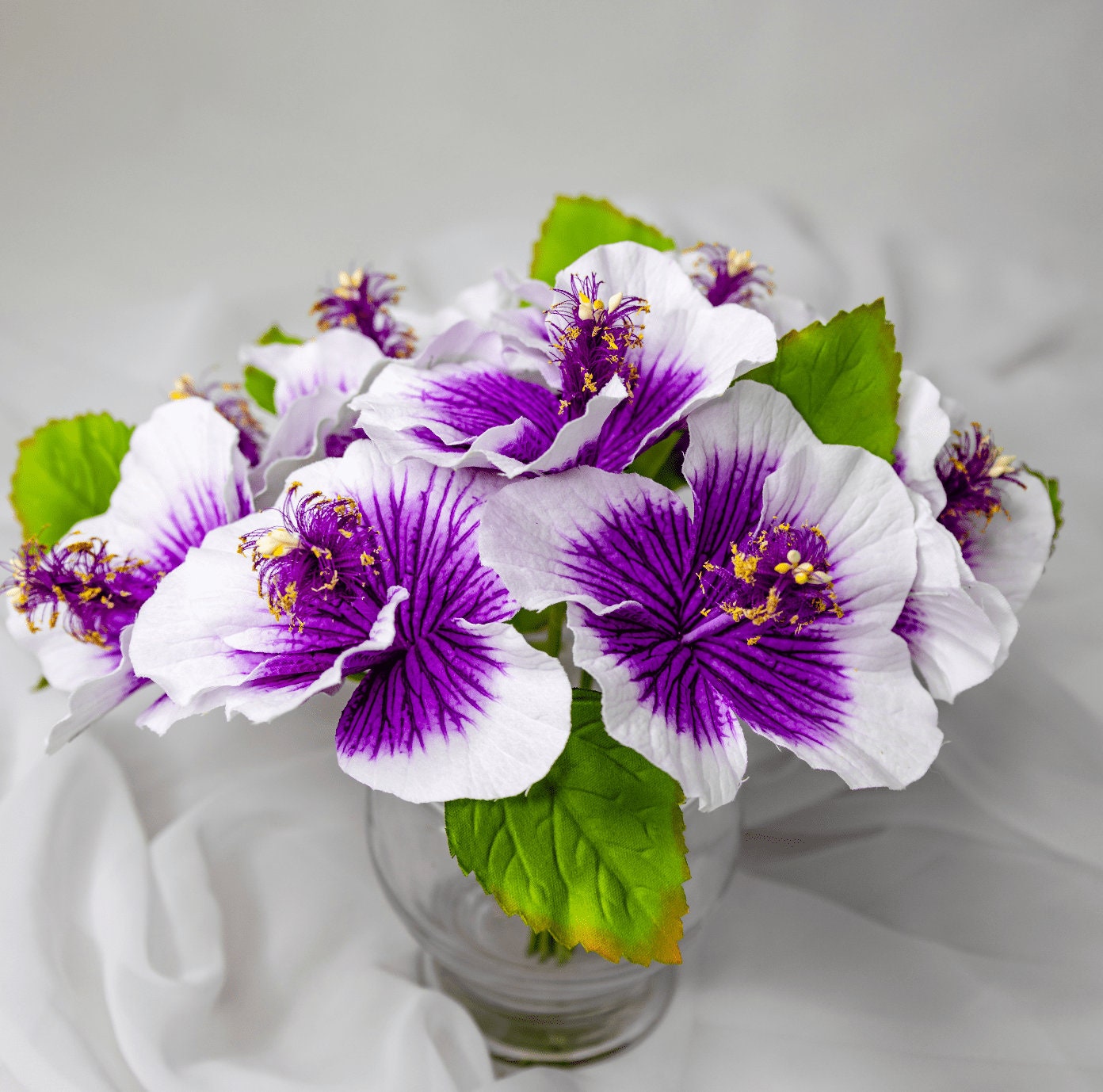 artificial Purple Hibiscus Flowerhead in clearglass vase