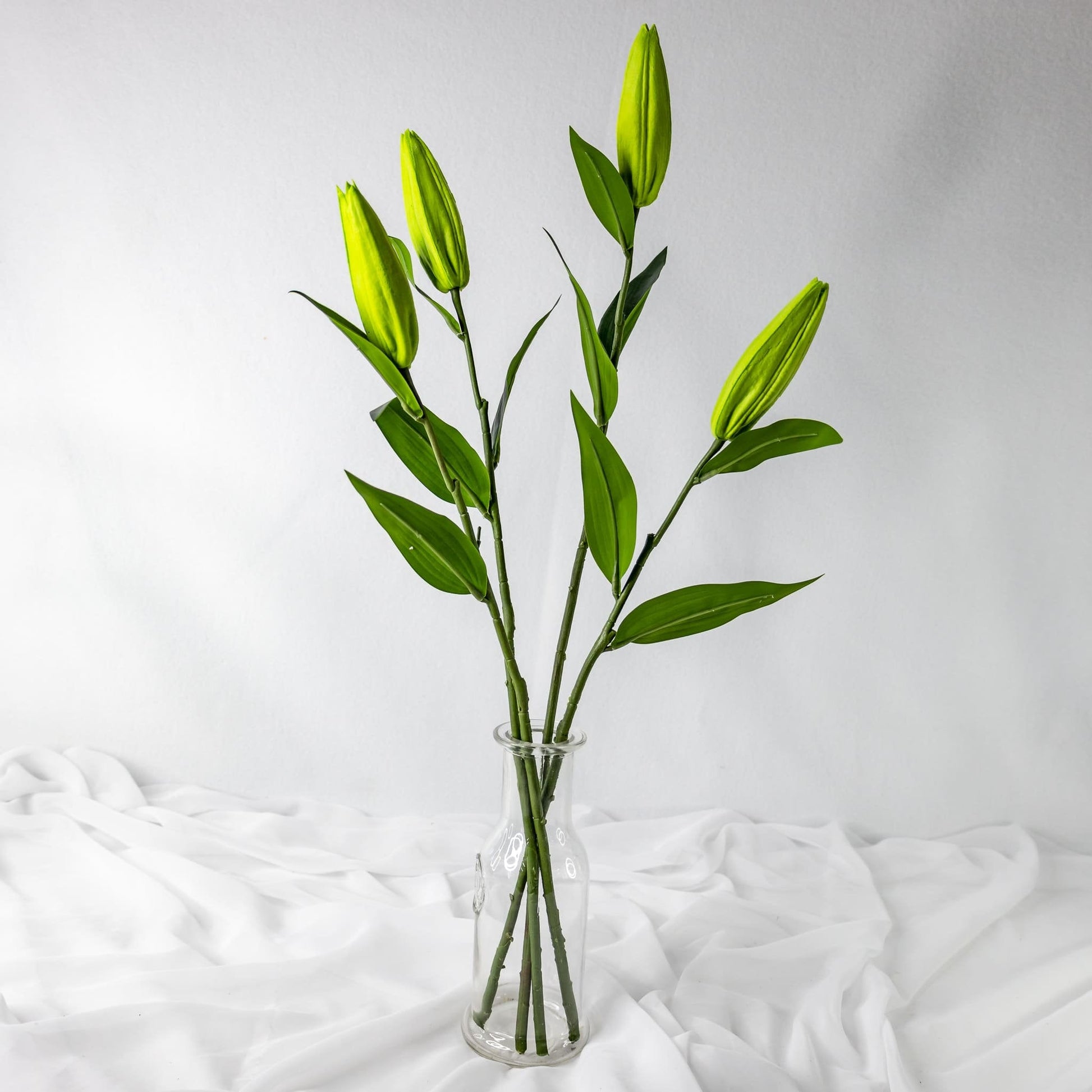 artificial Green Lily Buds in clear glass vase