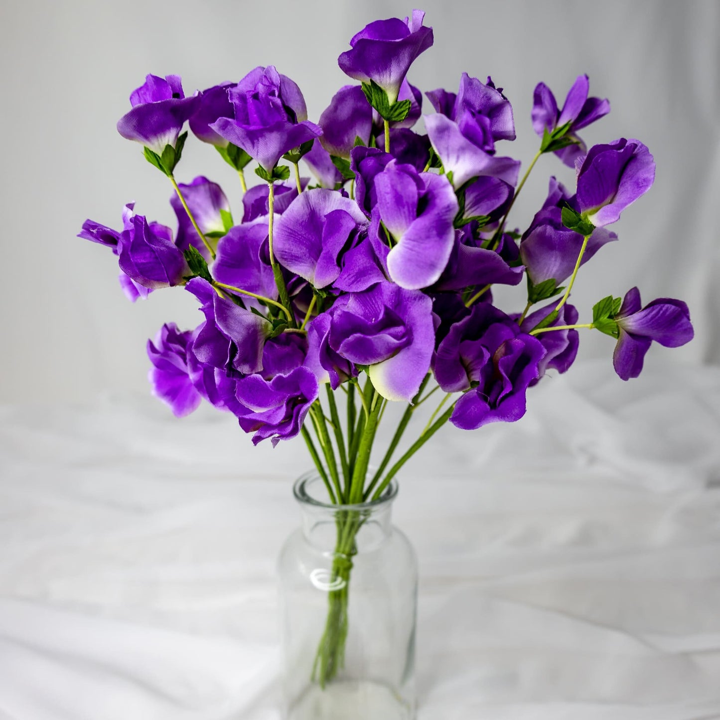 artificial Mauve Sweet Pea flowers in glass vase