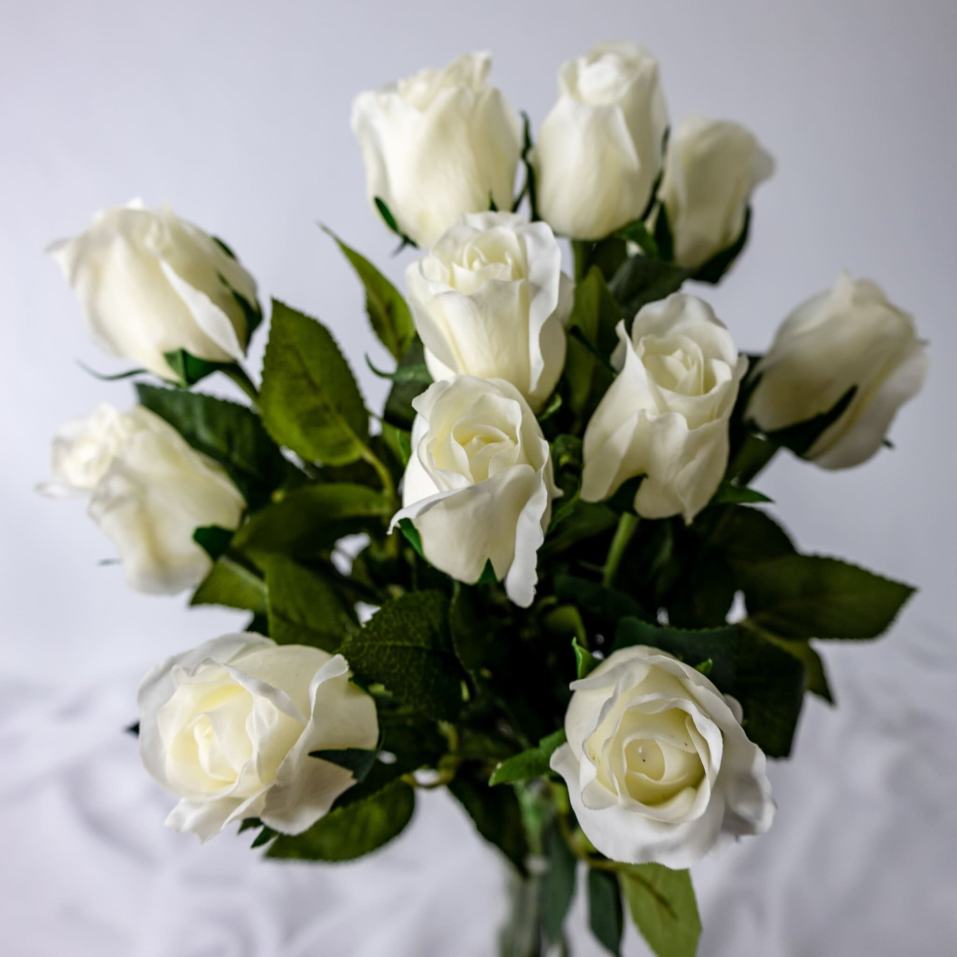 artificial Off White Real Touch Open Bud Roses in clear glass vase top view