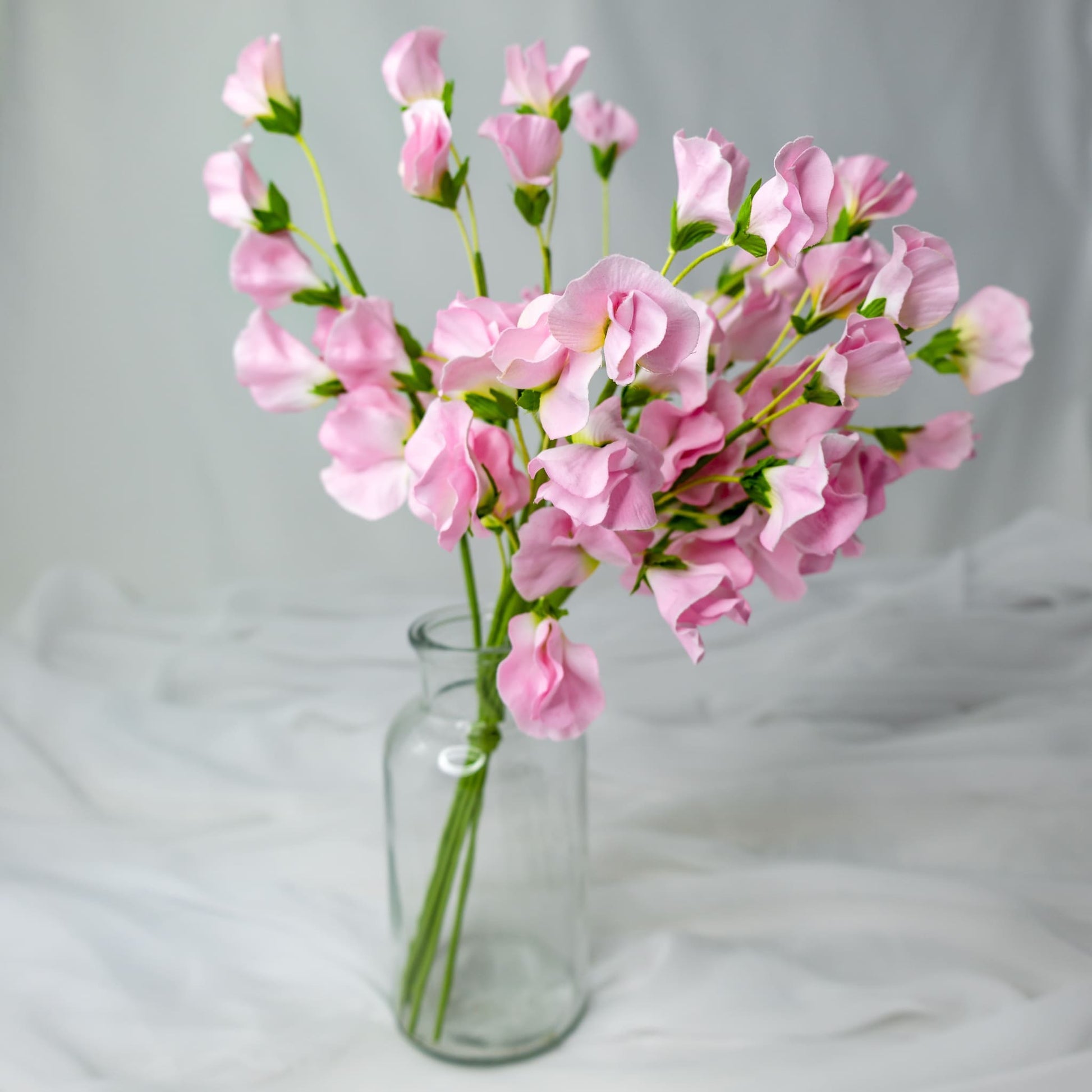 artificial Pink Sweet Peas in clear glass vase