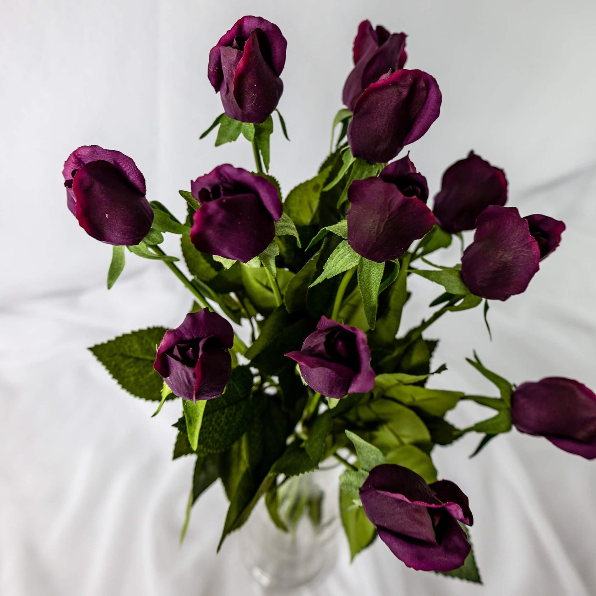 artificial Aubergine Real Touch Rose Buds in glass vase top view