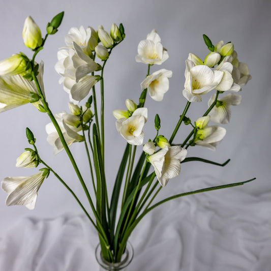 artificial Freesia in glass vase top view