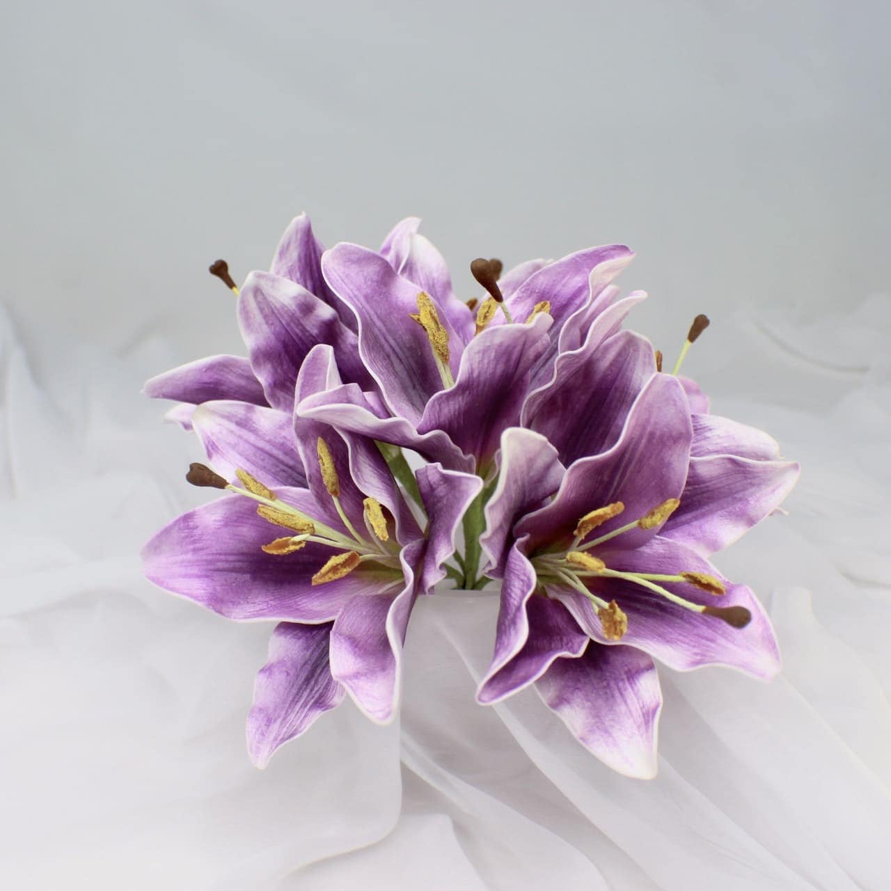 artificial purple lily flowerhead in clear glass vase