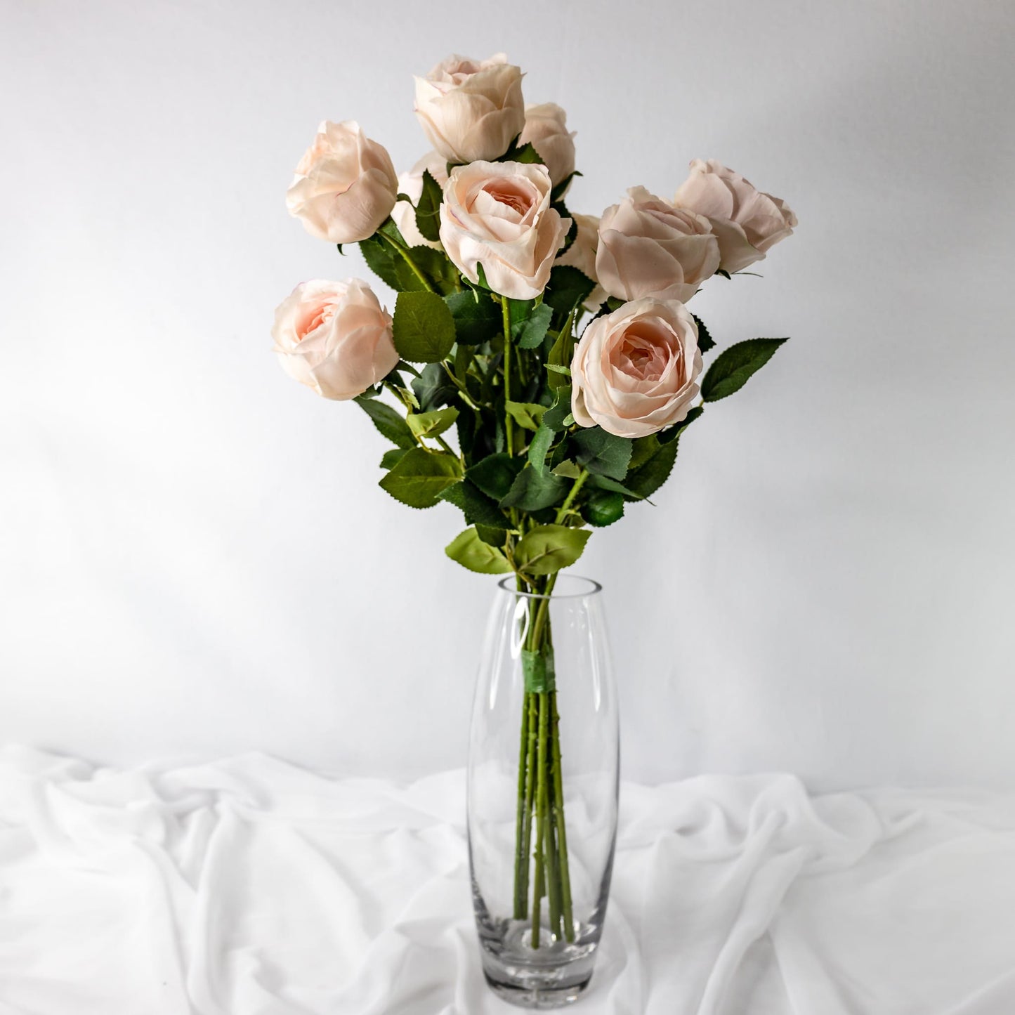 artificial light pink david austin roses placed in clear transparent glass