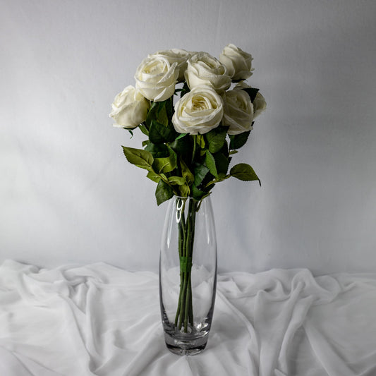 artificial white david austin open bud roses placed in transparent glass vase