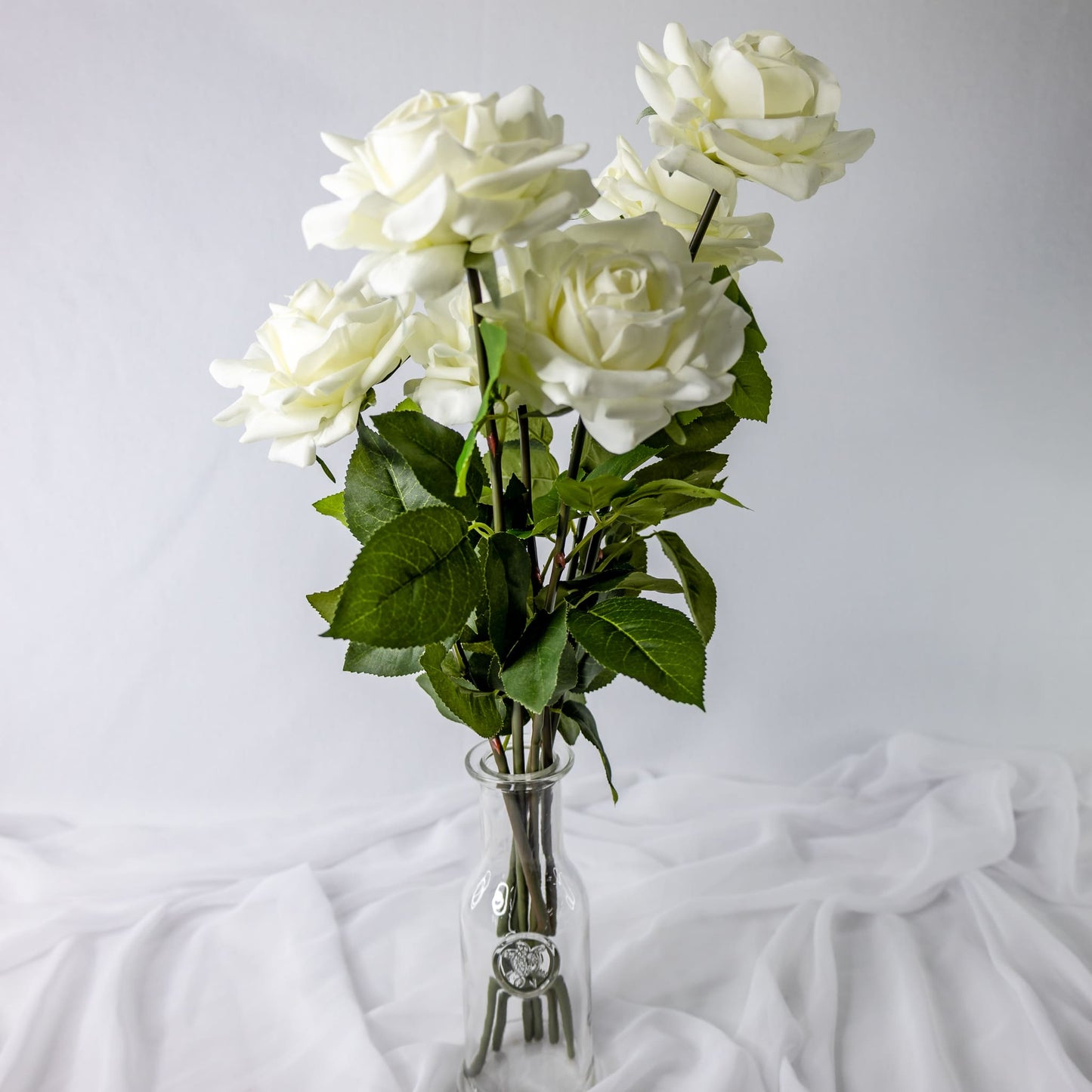 artificial white bloom roses placed in transparent glass vase