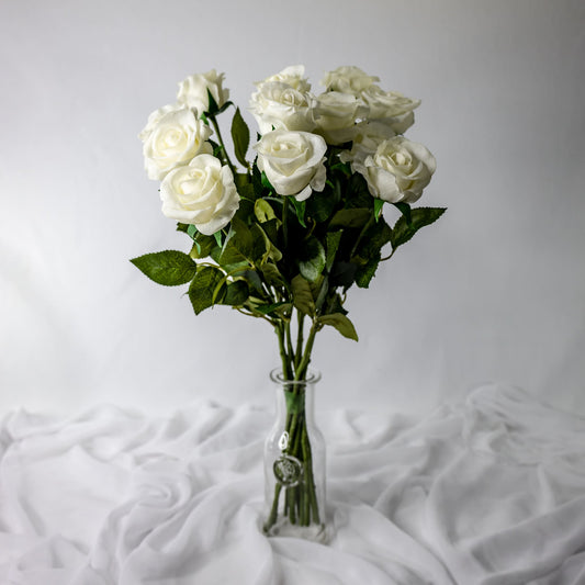 artificial white half bloom roses placed in transparent glass vase