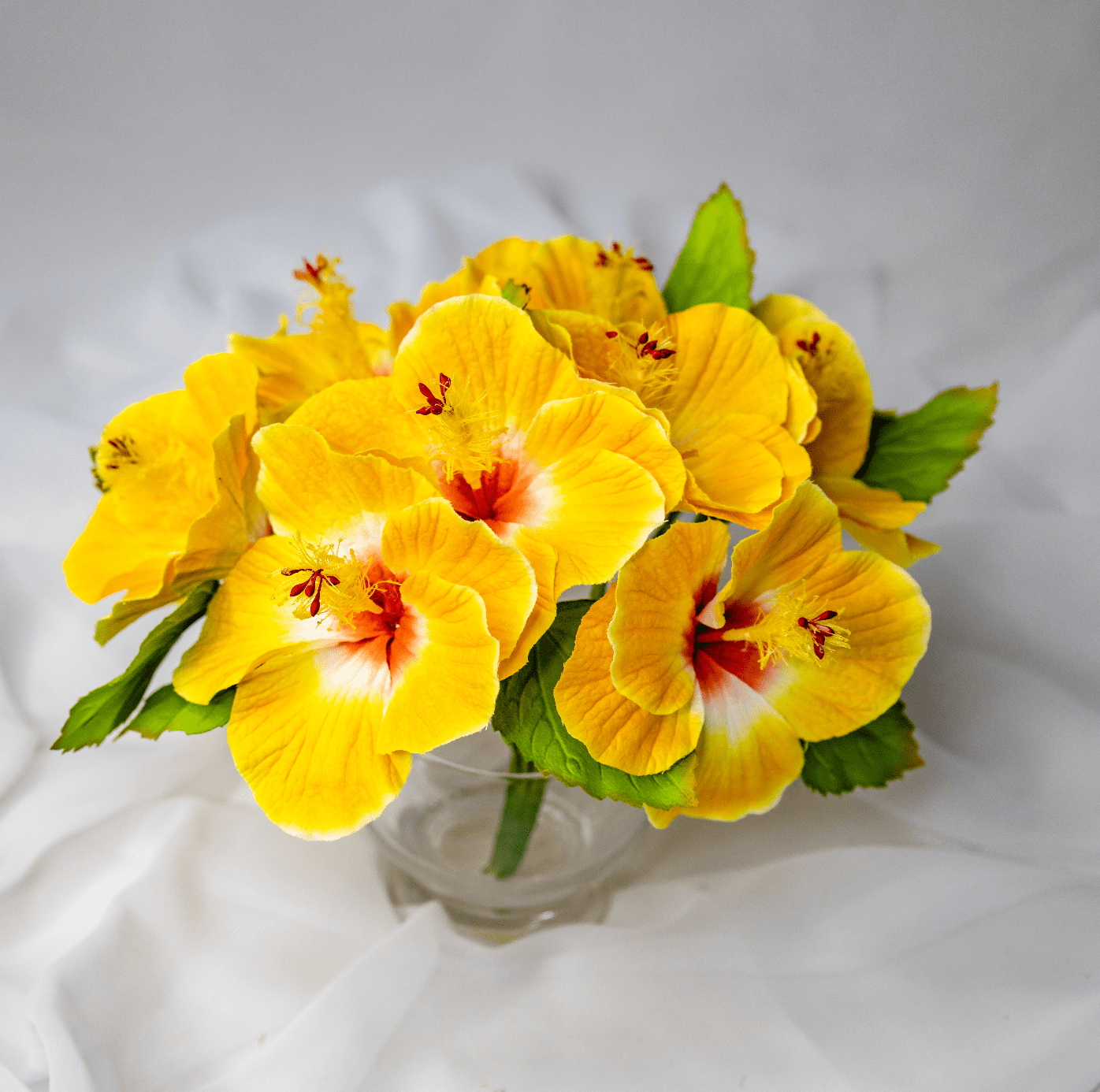 artificial Yellow Hibiscus Flowerhead in clear glass vase