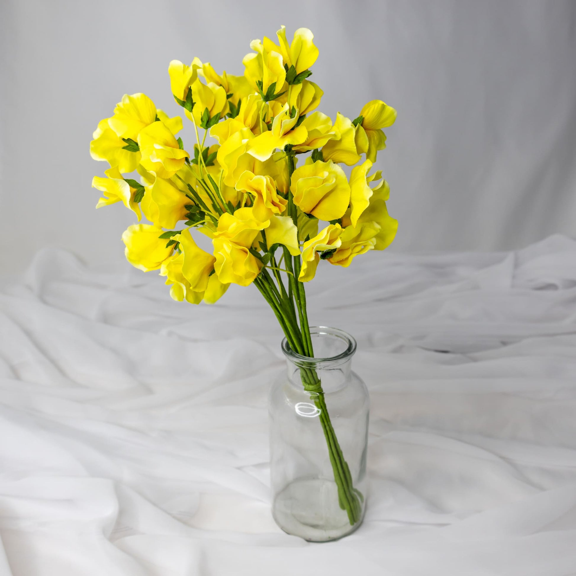 artificial yellow sweet pea in glass vase