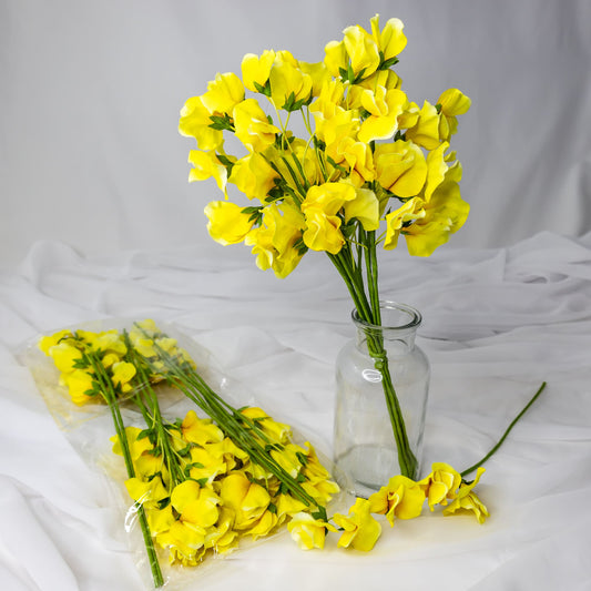 artificial yellow sweet pea in glass vase