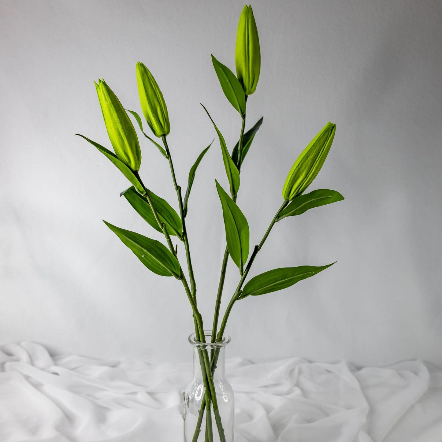 artificial Green Lily Buds in clear glass vase