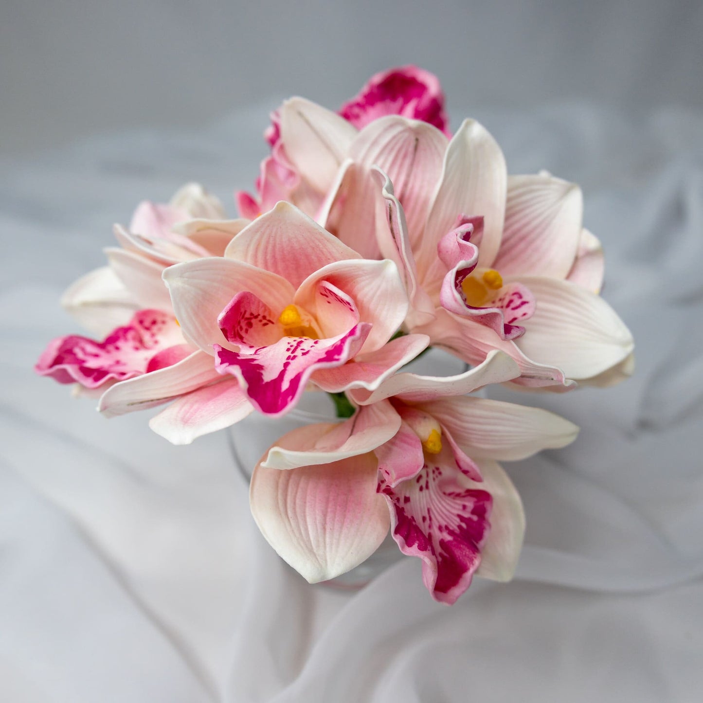 Artificial Pink Cymbidium in clear glass vase