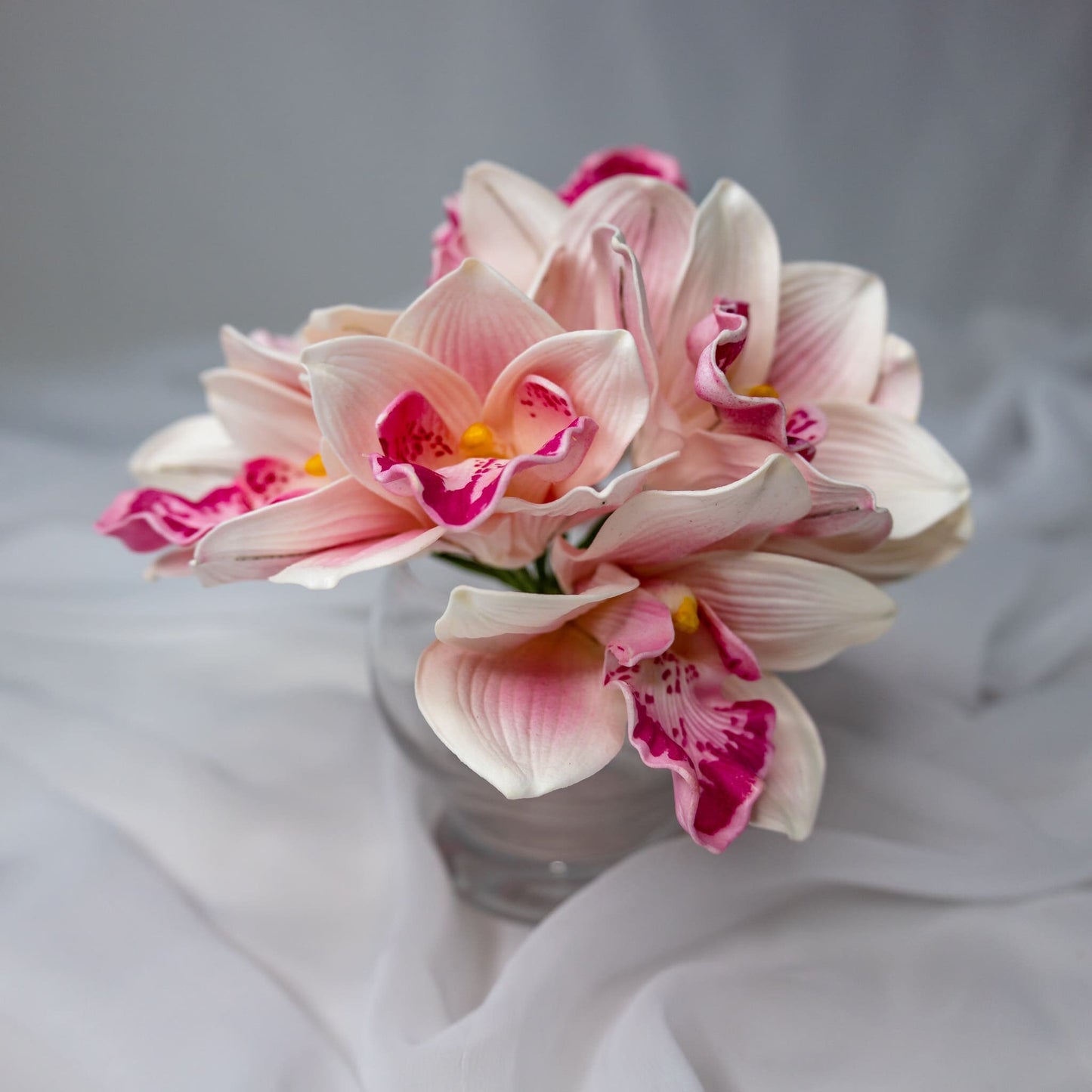 Artificial Pink Cymbidium in clear glass vase
