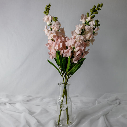 artificial Pink Snap Dragons in clear glass vase
