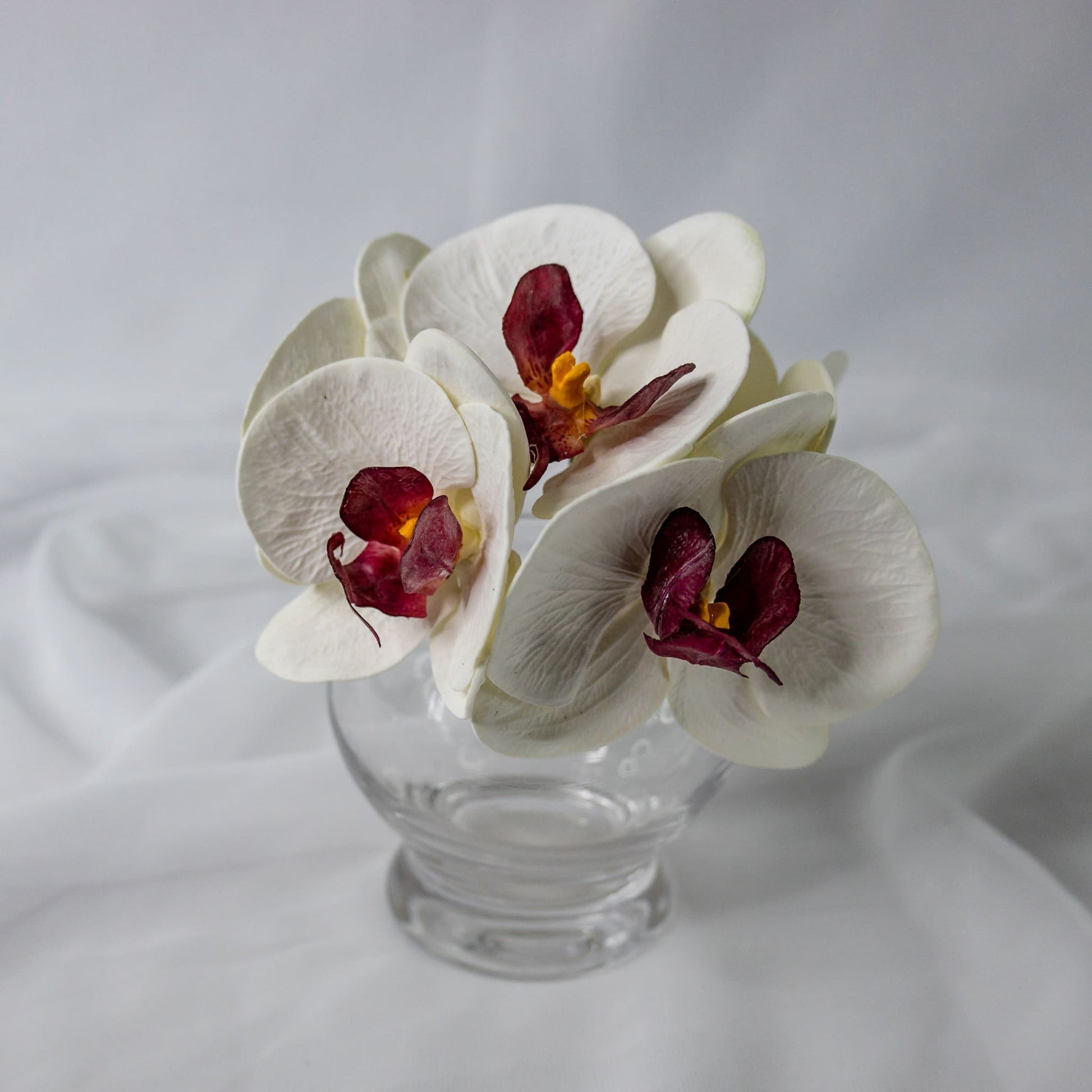 artificial white and dark pink phalaenopsis flower in clear glass vase