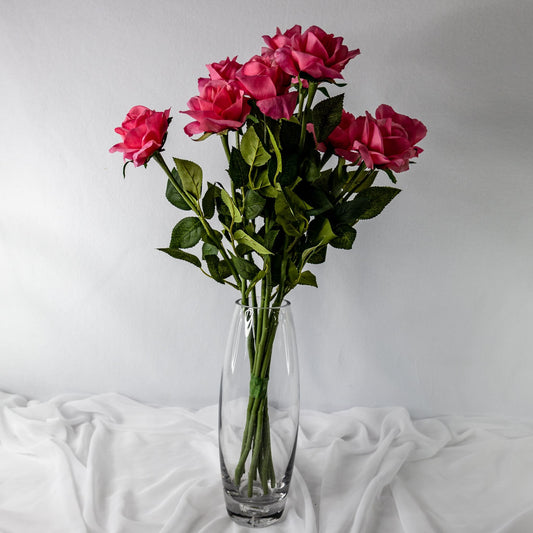 artificial pink real touch open bloom roses placed in glass transparent vase