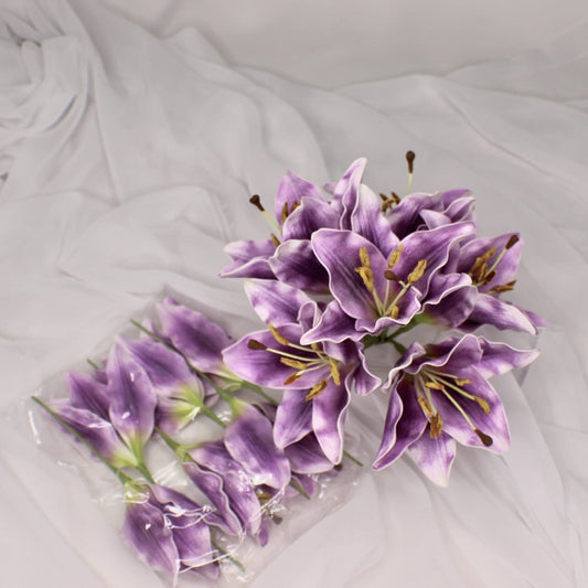 artificial purple lily flowerhead in clear glass vase